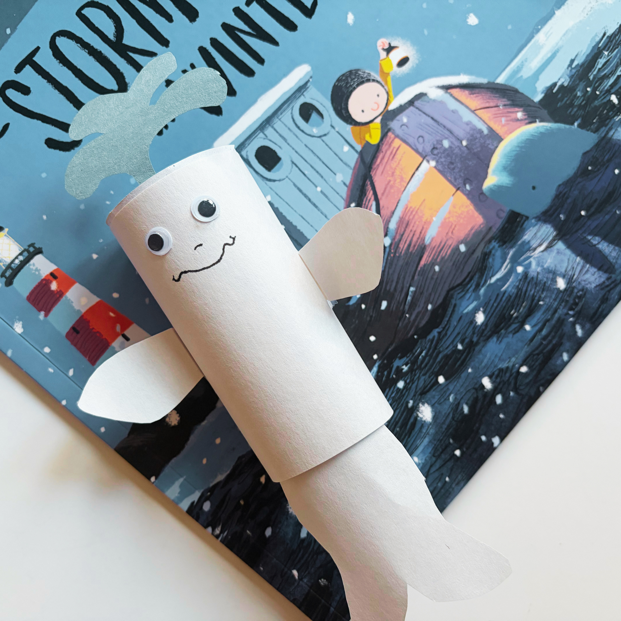 Close-up of finished polar animal craft—paper roll beluga whale—from the Snowy Days & Polar Ways preschool box.