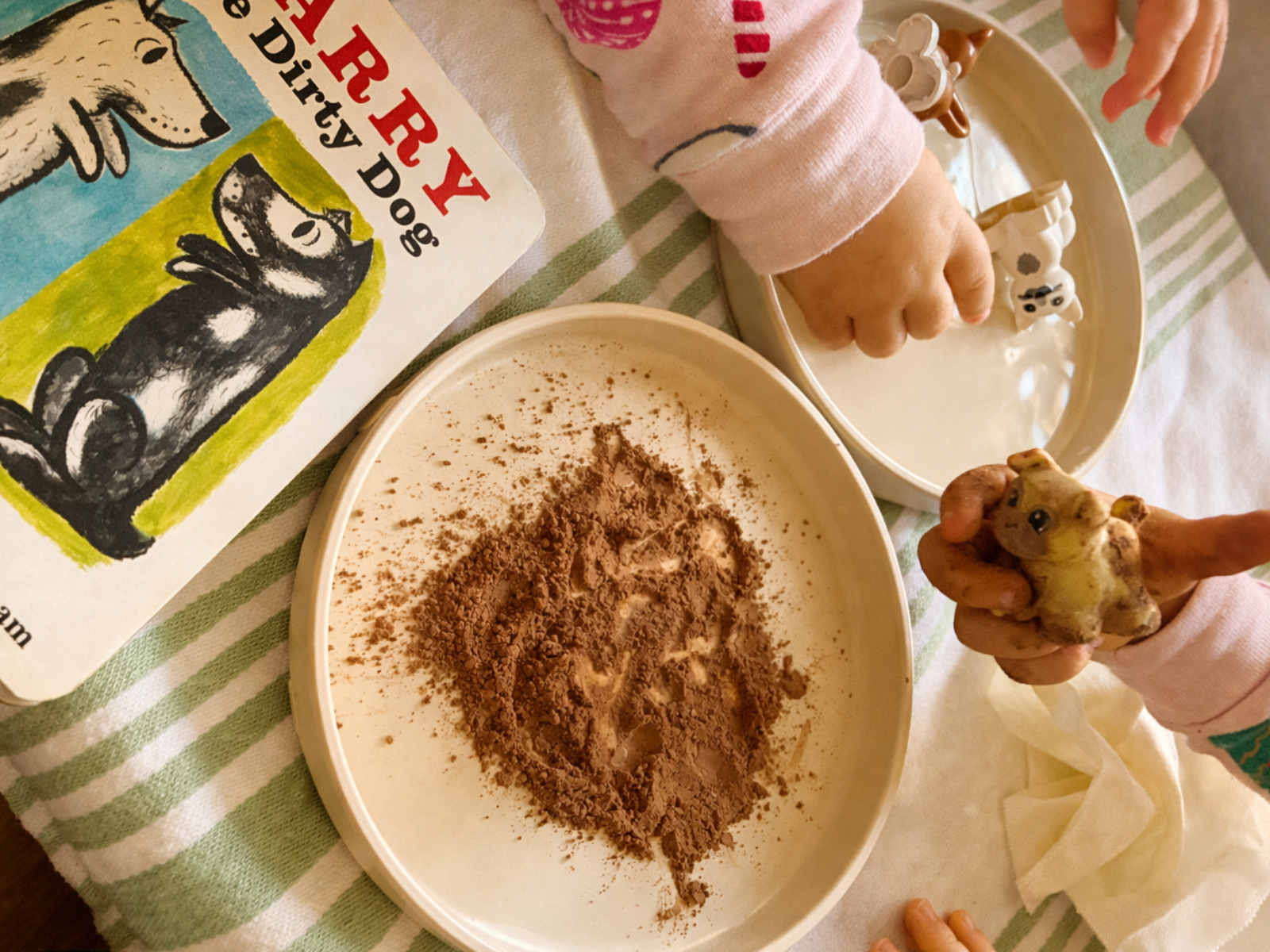 Child exploring cocoa powder sensory play activity inspired by Harry the Dirty Dog, part of a gentle play-based homeschool curriculum for early childhood learning