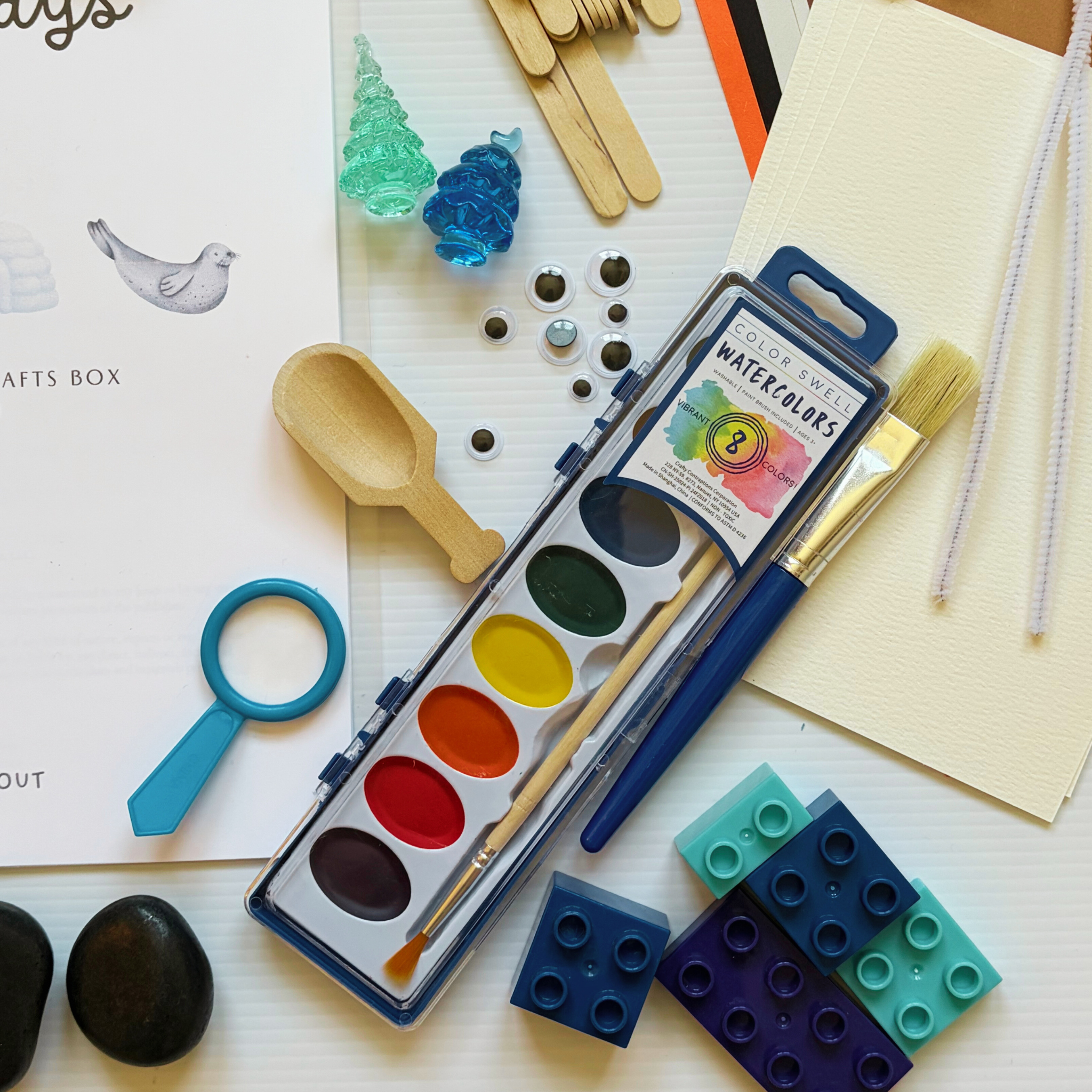 Winter sensory bin with icy rice, penguins, polar bears, scoops, and winter loose parts designed for hands-on preschool exploration.
