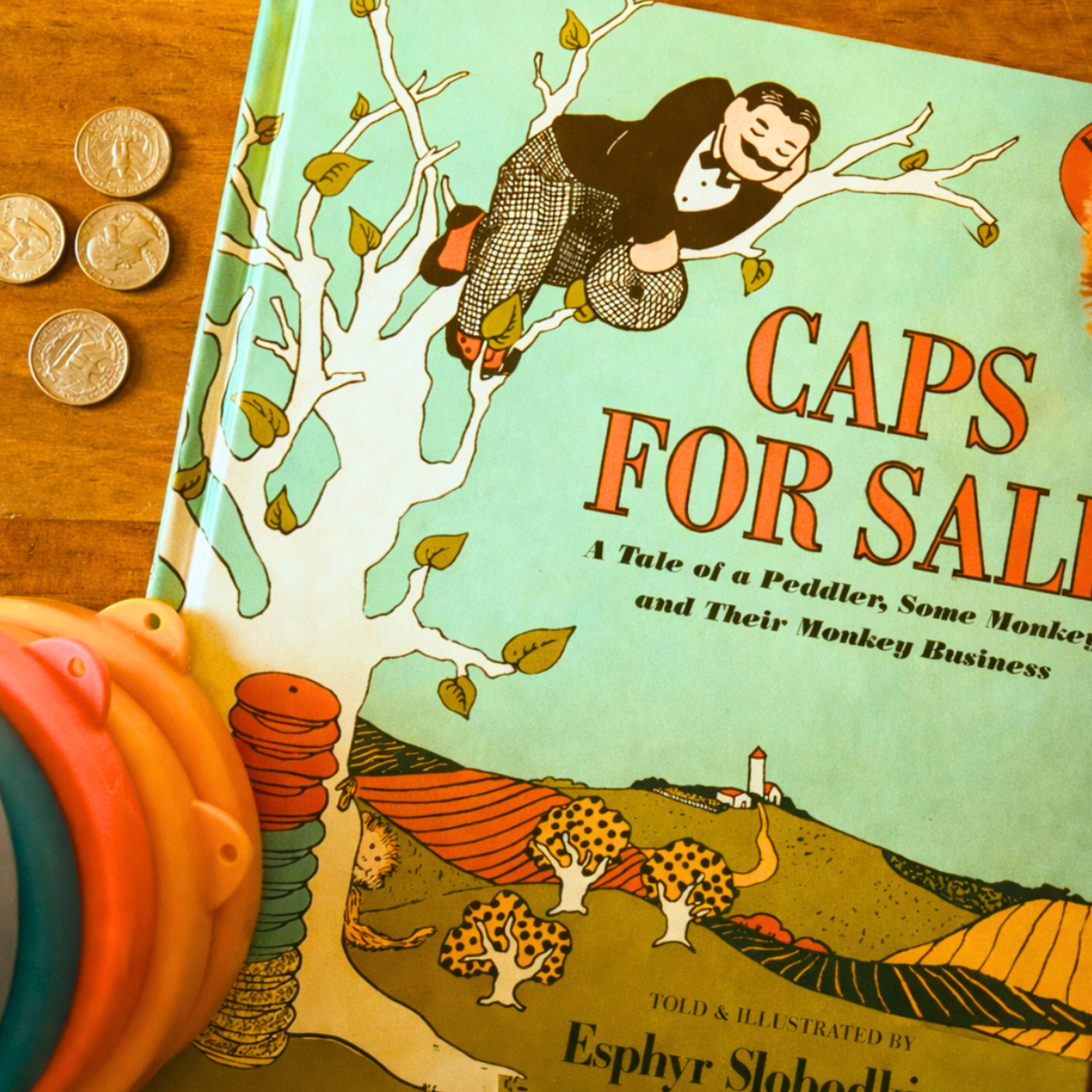 Caps for Sale picture book paired with counting materials for a hands-on preschool math activity in a literature-based curriculum.