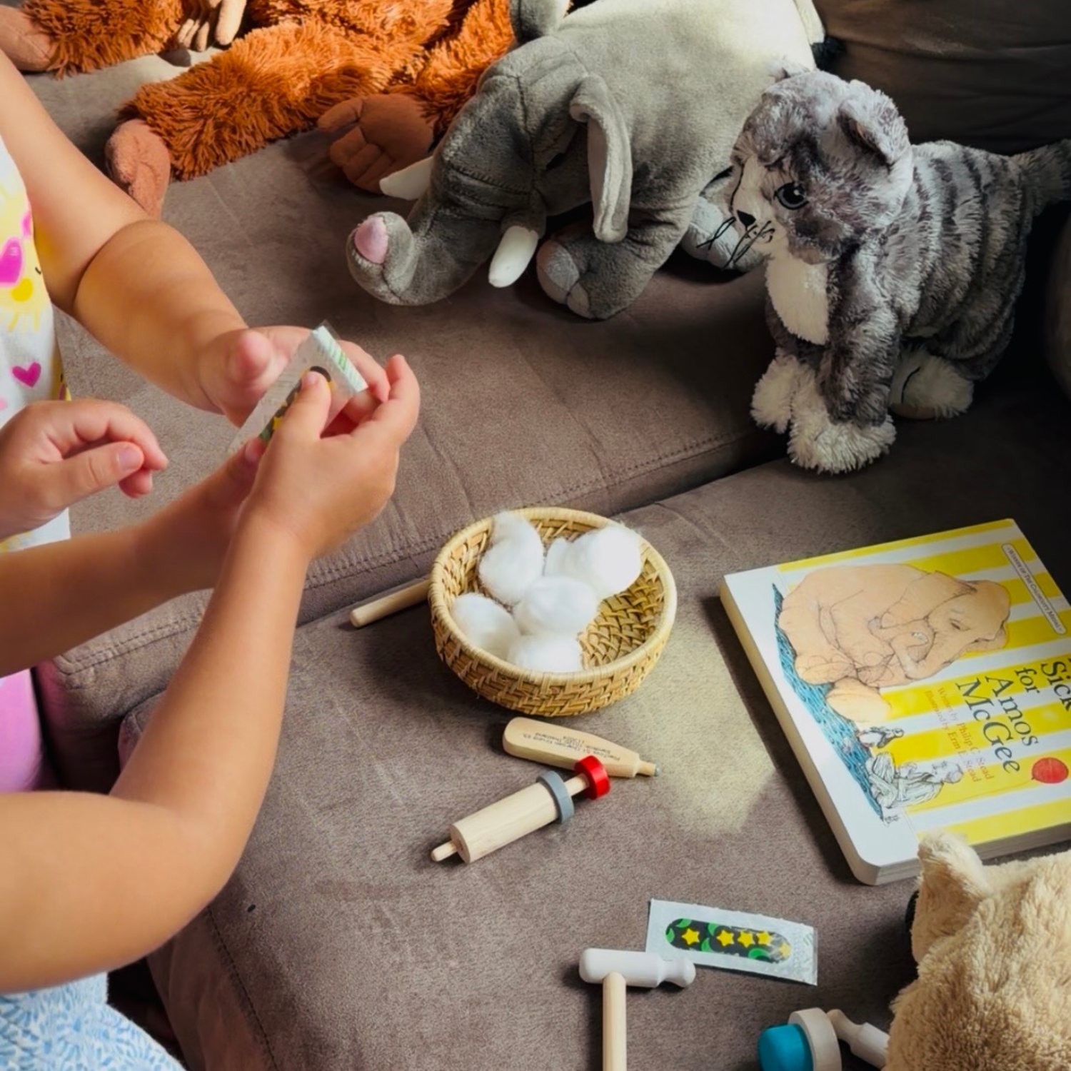 Children caring for stuffed animals in a pretend veterinary and doctor play activity inspired by A Sick Day for Amos McGee.