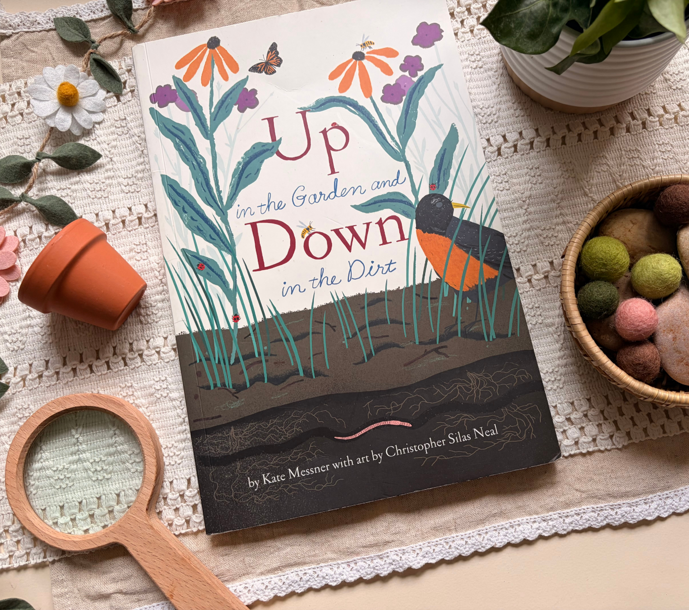 A picture book surrounded by simple learning materials, inviting families to begin their week with a shared story.