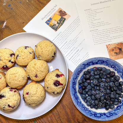 Homemade blueberry muffins, fresh blueberries, and Acorn to Sprout learning guide pages for Blueberries for Sal.
