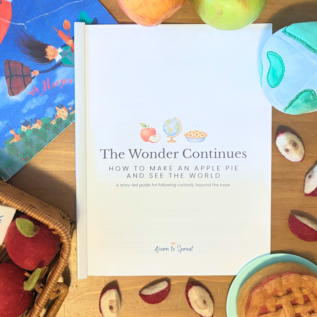 The Wonder Continues How to Make an Apple Pie and See the World preschool activity guide with the picture book, felt apples, globe, and apple pie