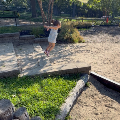 Child jumping outdoors during a movement activity inspired by Jabari Jumps.