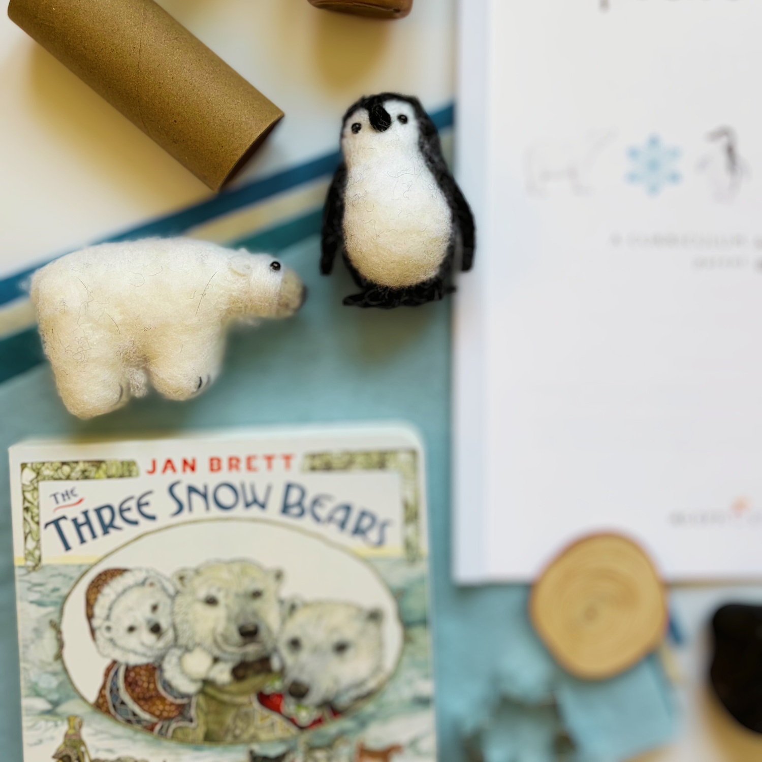 Snowy Days &amp; Polar Ways parent guide surrounded by included craft supplies, sensory items, and activity materials for a gentle winter homeschool theme.