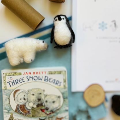 Snowy Days &amp; Polar Ways parent guide surrounded by included craft supplies, sensory items, and activity materials for a gentle winter homeschool theme.
