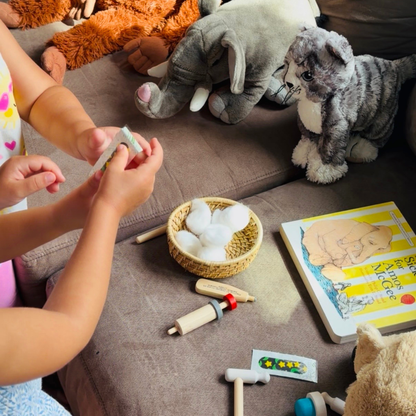 Children caring for stuffed animals with pretend medical supplies during play inspired by A Sick Day for Amos McGee.