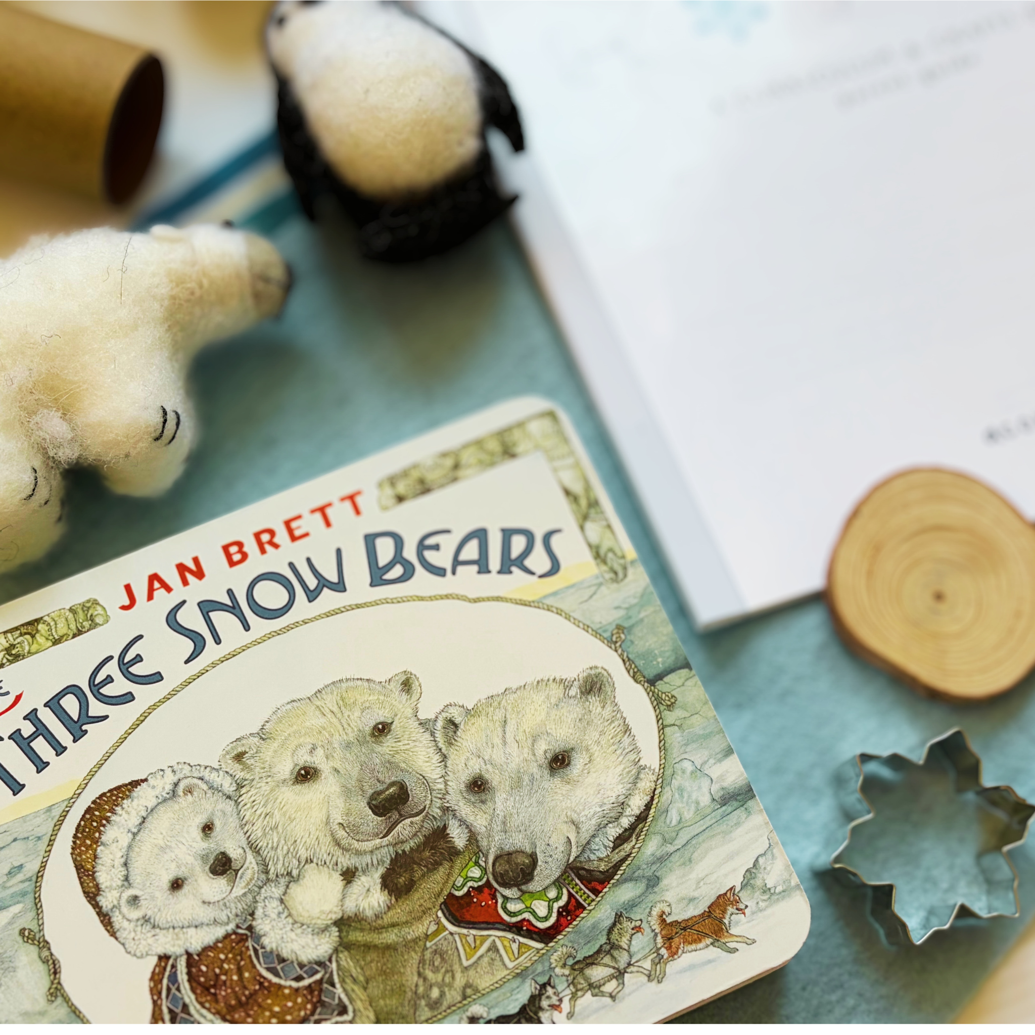 Parent and child reading The Three Snow Bears by Jan Brett as part of the Snowy Days &amp; Polar Ways winter curriculum box.